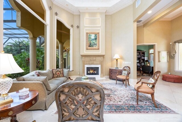 sitting room with a healthy amount of sunlight, ornamental molding, and a high ceiling