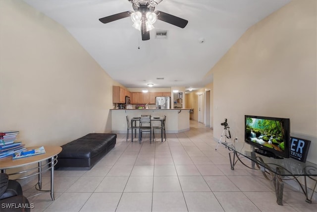 tiled living room with ceiling fan and vaulted ceiling