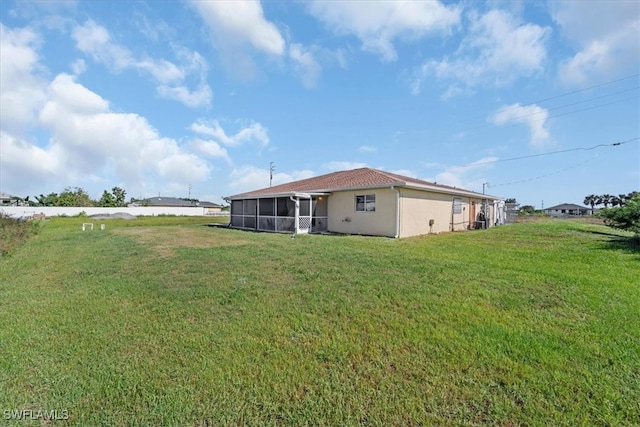 back of house with a lawn and a sunroom