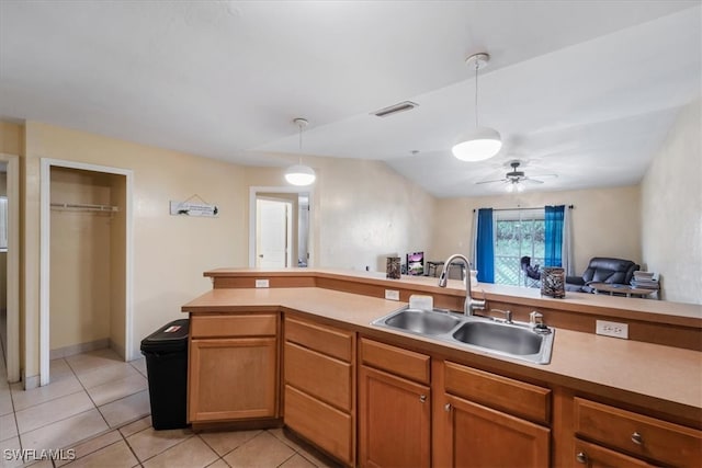 kitchen featuring sink, vaulted ceiling, ceiling fan, light tile patterned floors, and decorative light fixtures