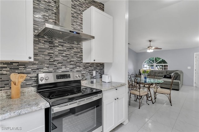 kitchen featuring tasteful backsplash, ceiling fan, stainless steel electric stove, wall chimney range hood, and white cabinetry