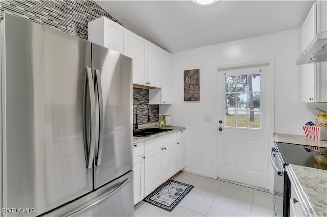 kitchen with white cabinets, sink, light tile patterned flooring, light stone counters, and stainless steel appliances