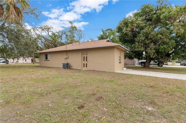 view of side of property featuring a yard and central AC unit