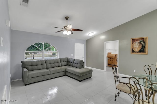 living room featuring ceiling fan, light tile patterned flooring, and vaulted ceiling