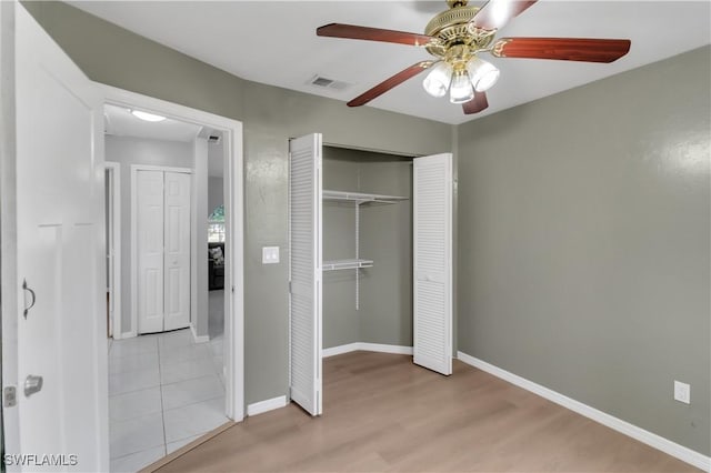 unfurnished bedroom with ceiling fan, a closet, and light hardwood / wood-style flooring