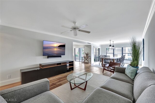 living room featuring ceiling fan, light hardwood / wood-style floors, and crown molding