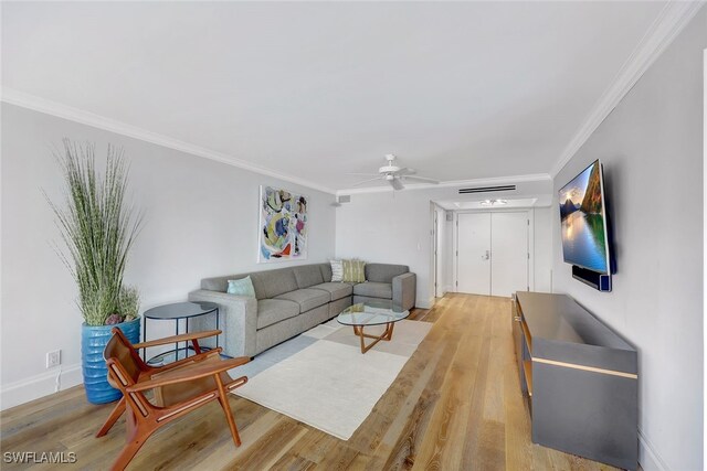 living room featuring ceiling fan, crown molding, and light hardwood / wood-style flooring