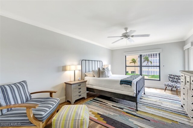 bedroom featuring ceiling fan, wood-type flooring, and ornamental molding