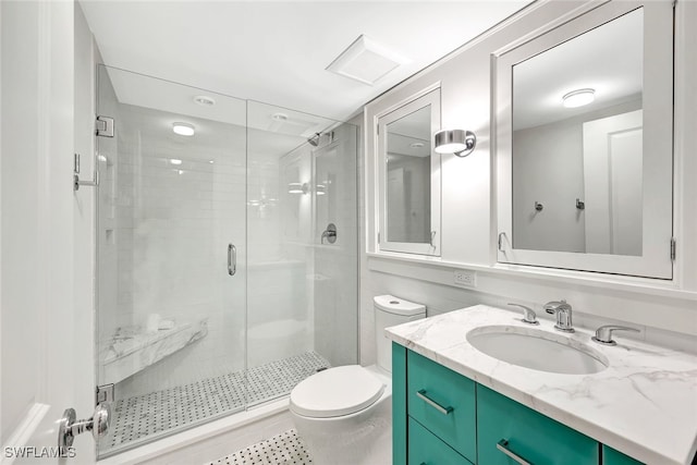 bathroom featuring vanity, a shower with shower door, and toilet