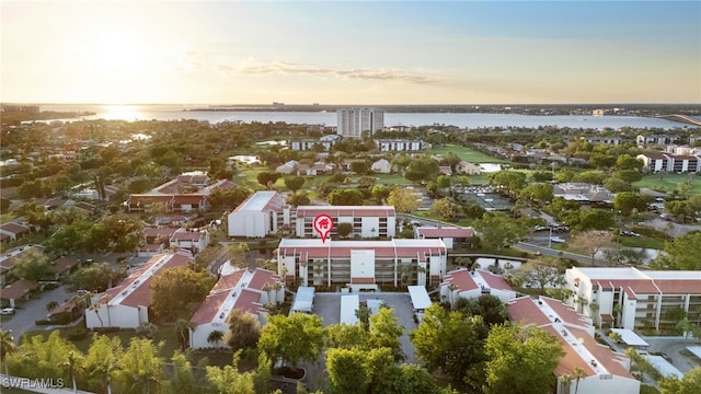 aerial view at dusk featuring a water view