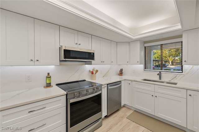 kitchen featuring white cabinets, stainless steel appliances, light hardwood / wood-style flooring, and sink