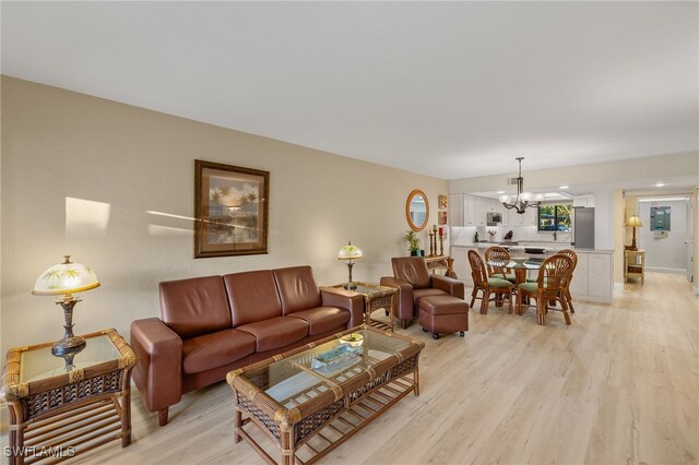 living room featuring an inviting chandelier and light hardwood / wood-style flooring