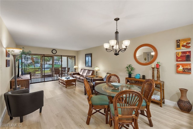 dining room with light hardwood / wood-style flooring and an inviting chandelier