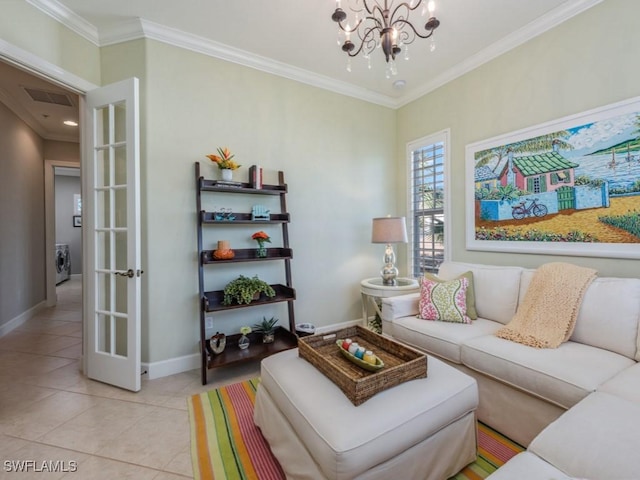 living room with light tile patterned floors, crown molding, a chandelier, and washer / dryer