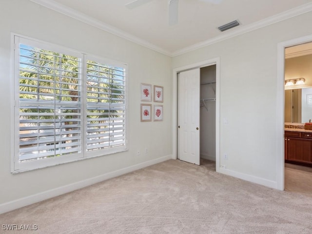 unfurnished bedroom featuring light carpet, a closet, ornamental molding, ceiling fan, and ensuite bathroom