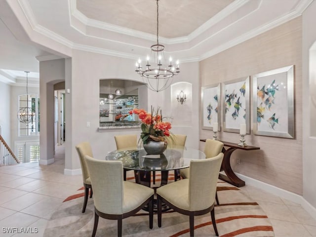 tiled dining room featuring crown molding, a raised ceiling, and a chandelier