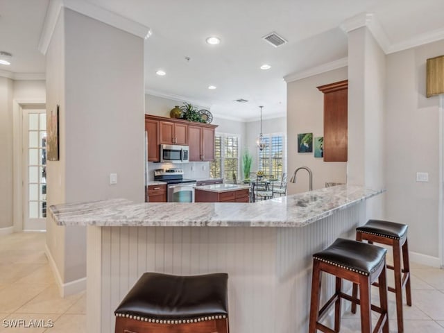 kitchen featuring a kitchen bar, crown molding, kitchen peninsula, and stainless steel appliances