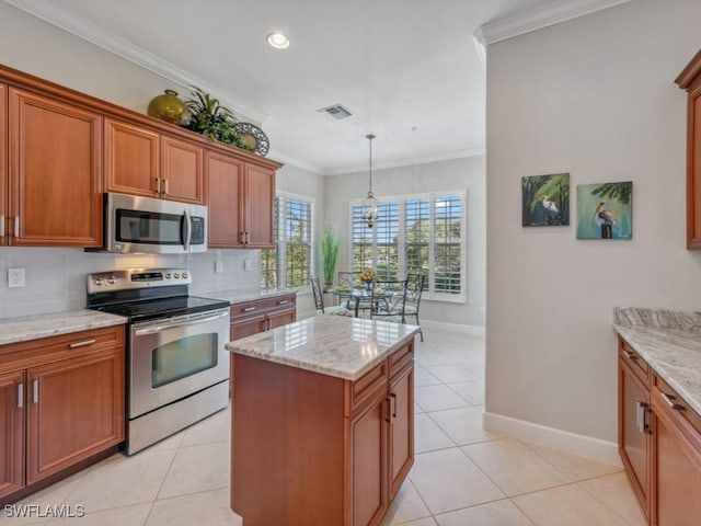 kitchen with light tile patterned floors, crown molding, stainless steel appliances, and pendant lighting