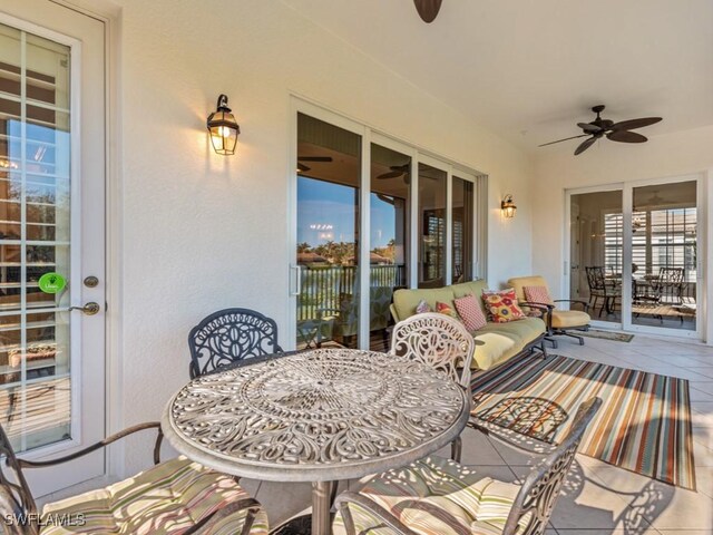 carpeted bedroom with ceiling fan, a tray ceiling, multiple windows, and ornamental molding