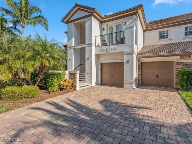 view of front of home featuring a garage and a balcony