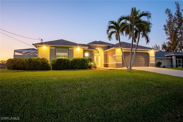 view of front of property with a yard and a garage