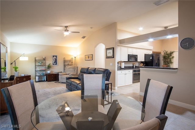 tiled dining area with ceiling fan and vaulted ceiling
