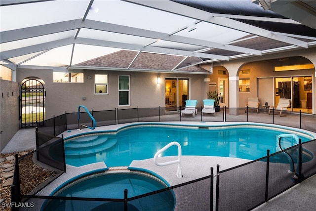 view of pool with an in ground hot tub, glass enclosure, and a patio area