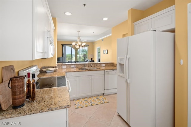 kitchen with kitchen peninsula, white appliances, sink, a chandelier, and white cabinetry