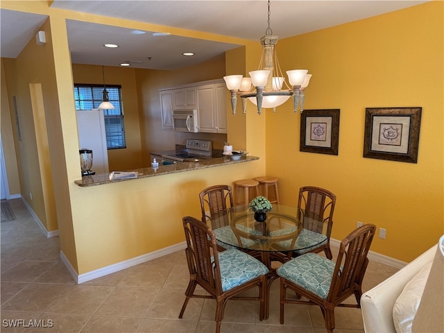 tiled dining space with a chandelier