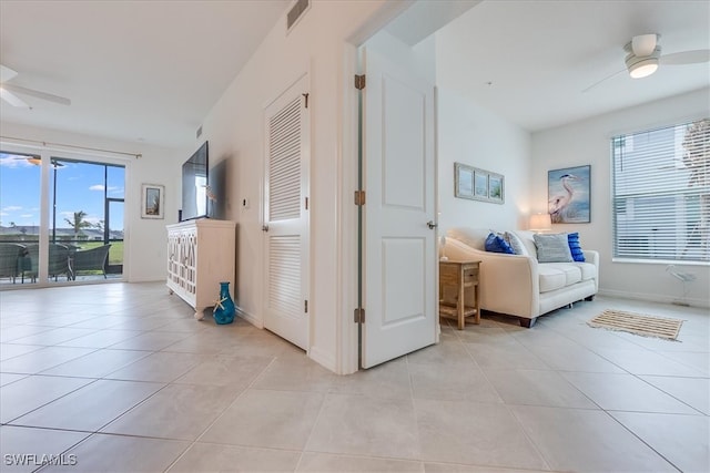 hall with light tile patterned floors and a healthy amount of sunlight