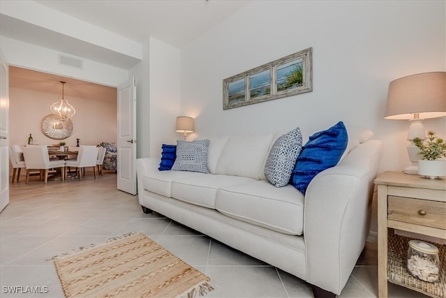 living room featuring a notable chandelier and light tile patterned flooring