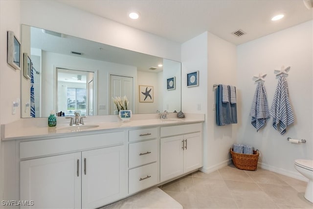 bathroom with tile patterned flooring, vanity, and toilet