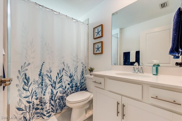 bathroom featuring tile patterned flooring, vanity, and toilet