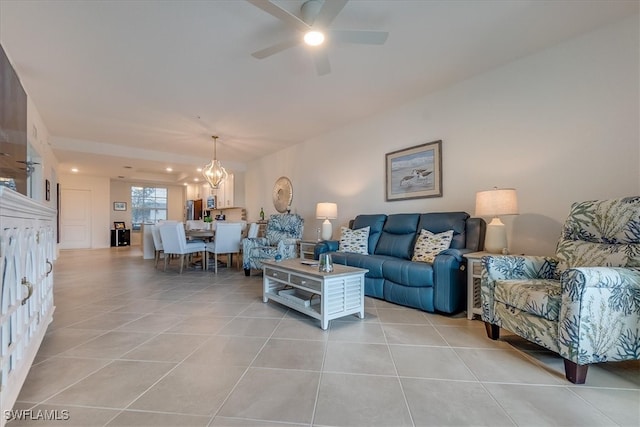 tiled living room featuring ceiling fan with notable chandelier