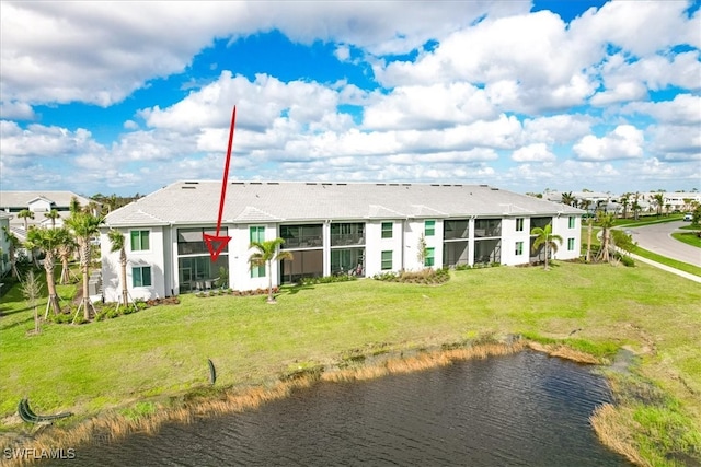 rear view of house with a yard and a water view