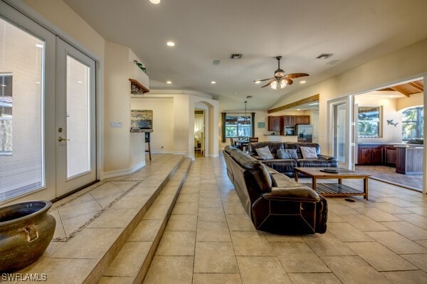 living room featuring french doors, light tile patterned floors, vaulted ceiling, and ceiling fan