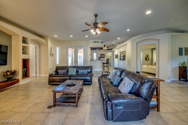 tiled living room featuring ceiling fan and french doors