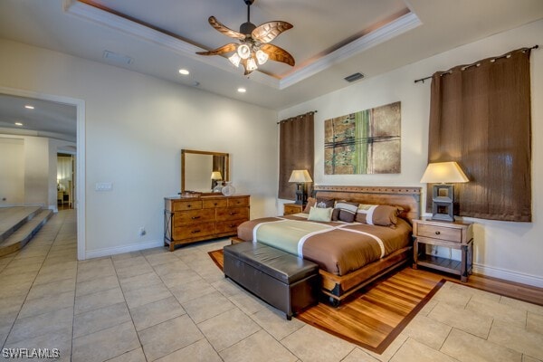 bedroom featuring ceiling fan, a raised ceiling, ornamental molding, and light tile patterned floors