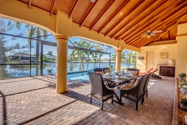 view of patio / terrace with glass enclosure, ceiling fan, and a water view