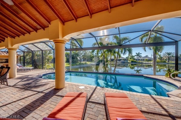 view of pool with a water view, a patio area, and a lanai