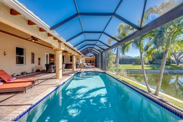 view of pool featuring a lanai, ceiling fan, a water view, and a patio