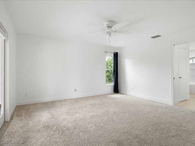 spare room with ceiling fan and light colored carpet