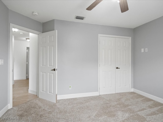 unfurnished bedroom with ceiling fan, a closet, and light colored carpet