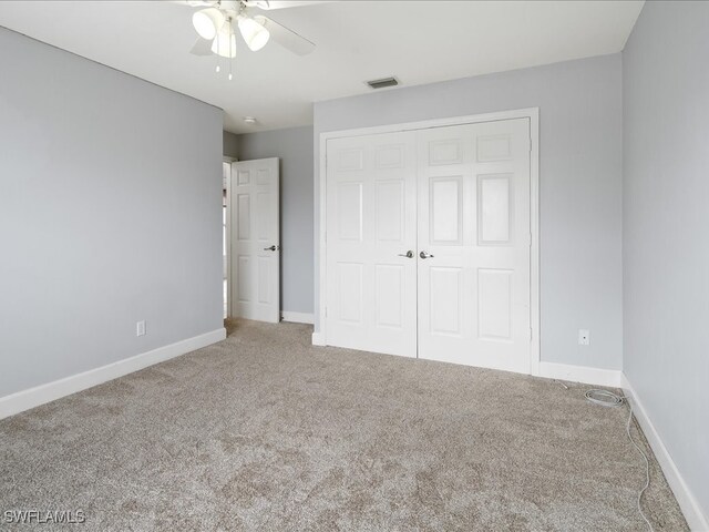 unfurnished bedroom with ceiling fan, a closet, and carpet