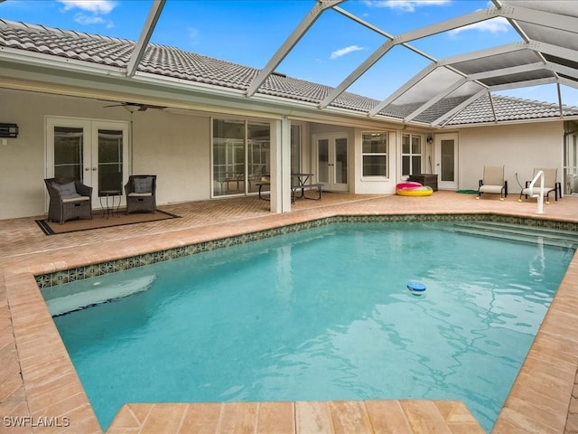 view of pool with a lanai, a patio, and french doors