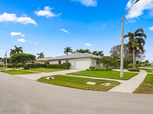 ranch-style home with a garage and a front lawn