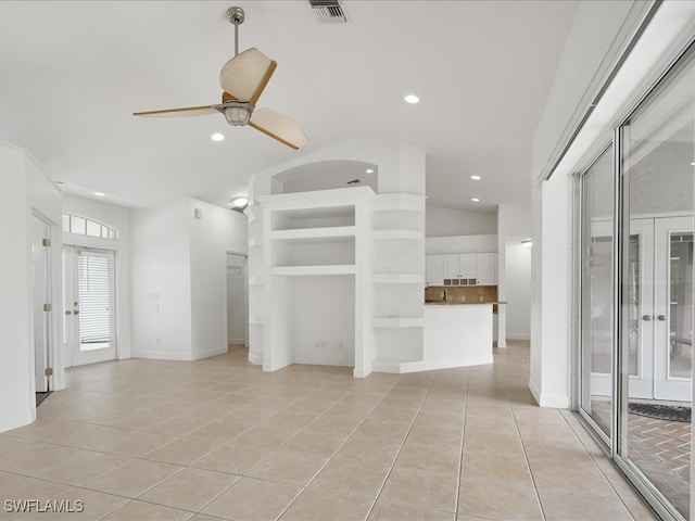 unfurnished living room with ceiling fan, french doors, light tile patterned floors, and lofted ceiling