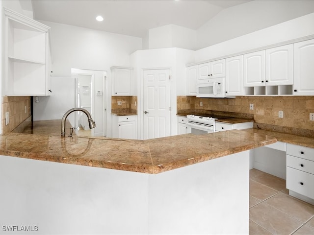 kitchen with kitchen peninsula, vaulted ceiling, white appliances, decorative backsplash, and white cabinets