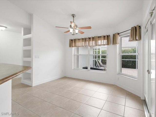 unfurnished dining area with ceiling fan and light tile patterned floors