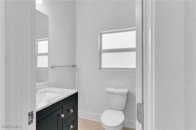 bathroom with tile patterned flooring, vanity, and toilet